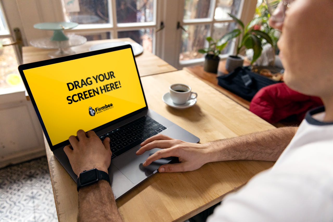 about-01 Over-the-shoulder view of a person using a laptop indoors with a placeholder screen for customization.